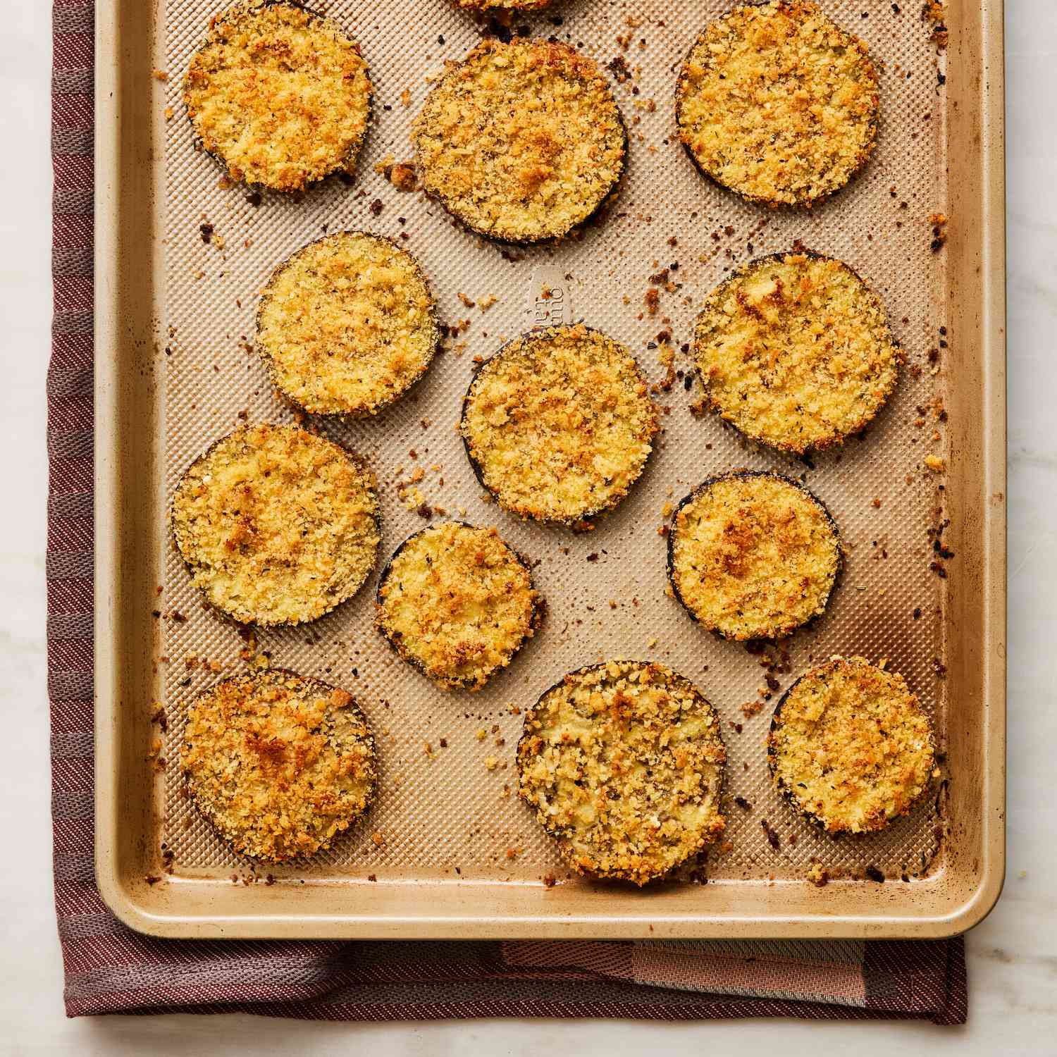 cooked, panko crusted, eggplant slices on a sheet pan
