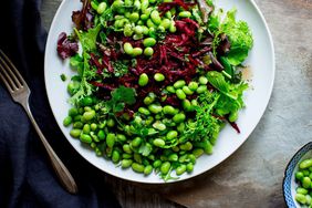edamame and beet salad with fresh herbs and spring mix on a plate