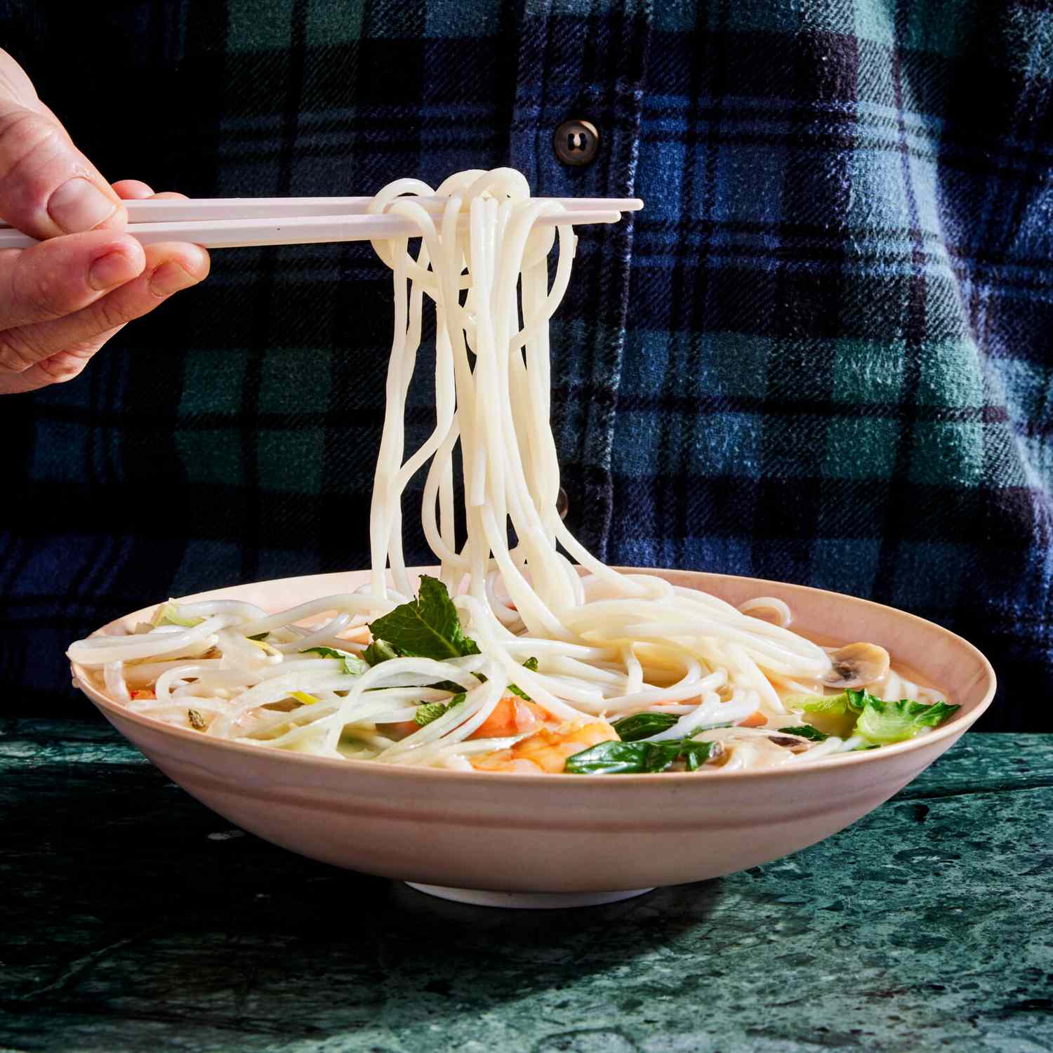 hand holding chopsticks showing noodles from Bok Choy Soup with Shrimp and Noodles