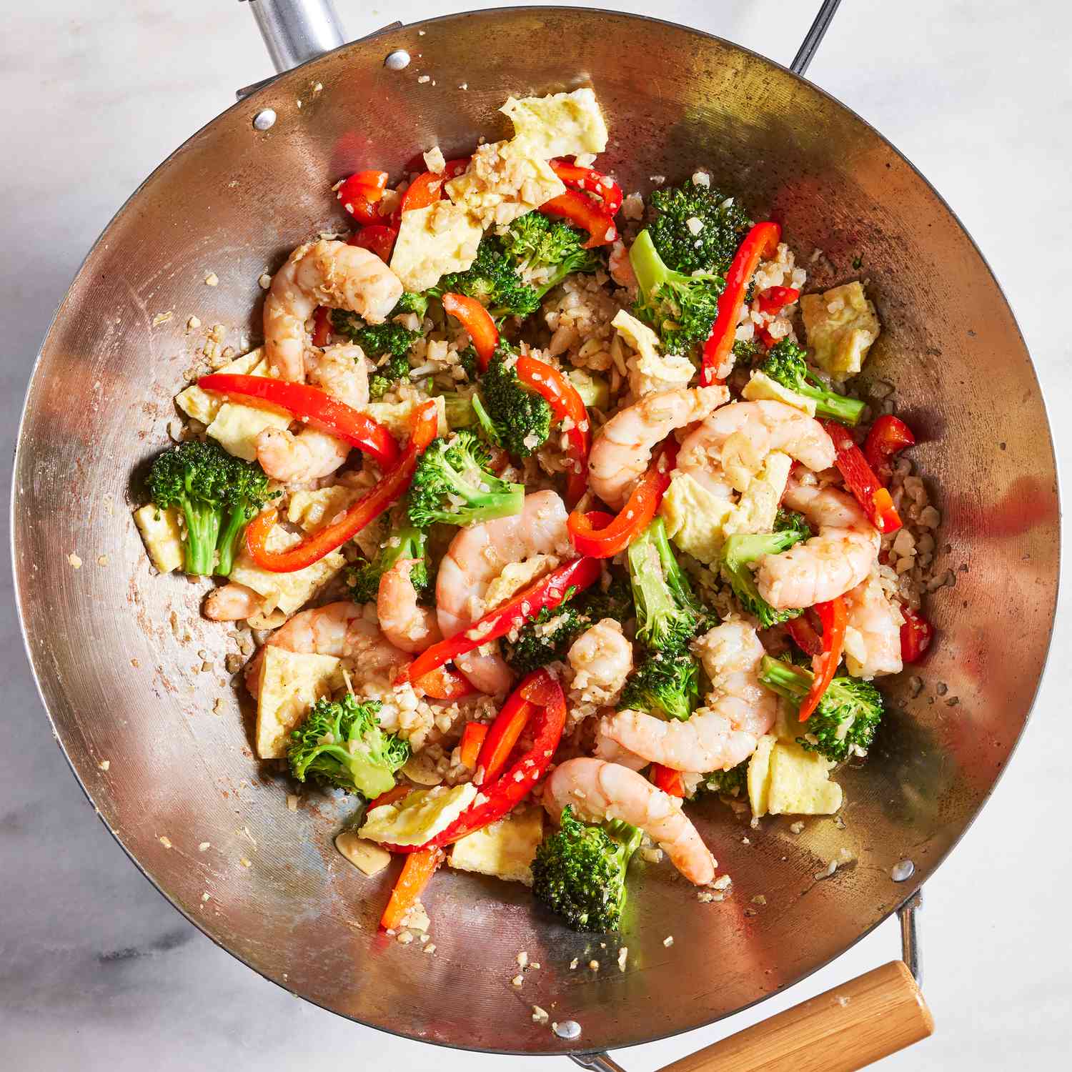 Overhead view after eggs added to Shrimp Cauliflower Fried Rice recipe cooking in a wok