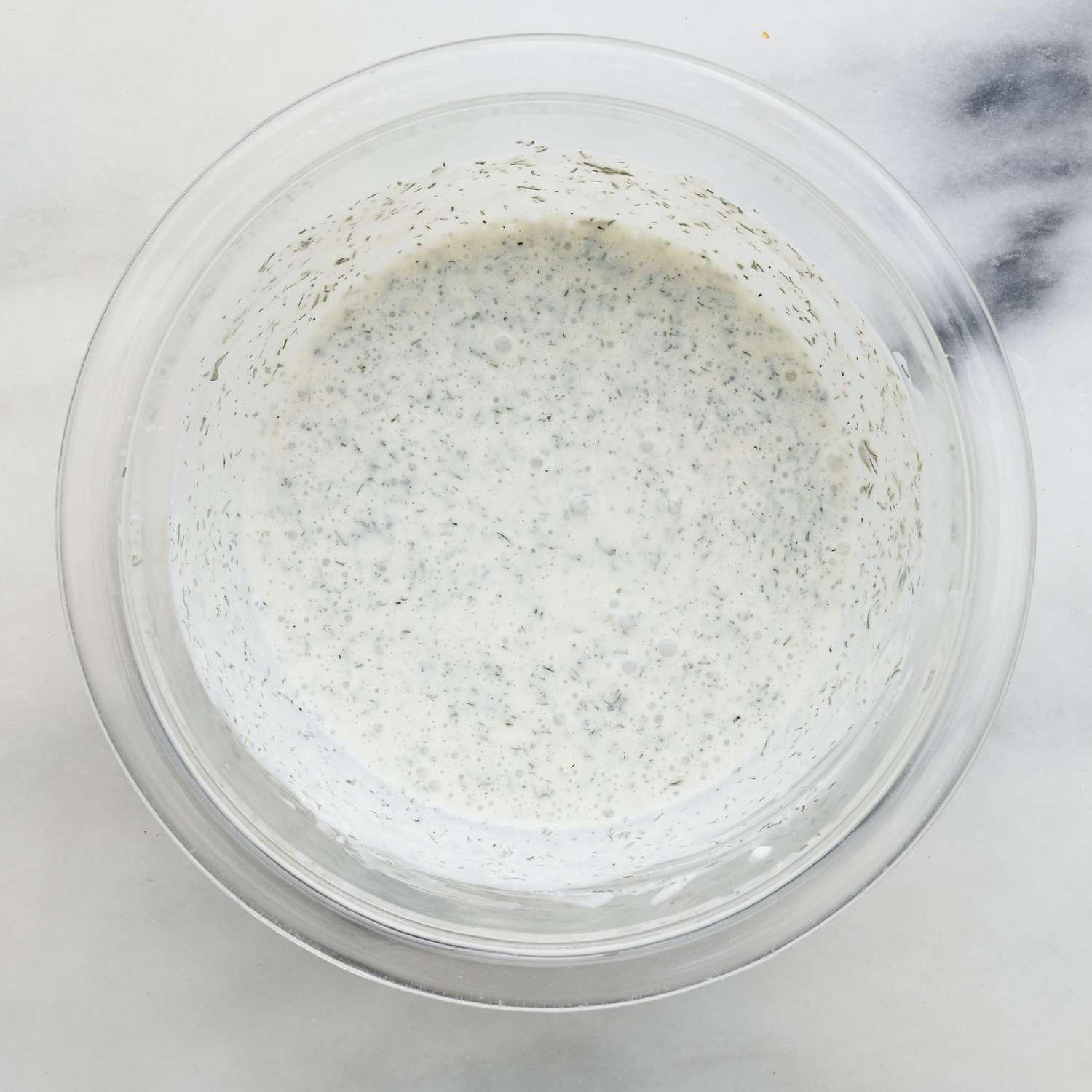 A white sauce mixture in a clear bowl