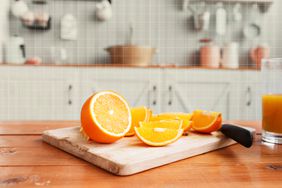 sliced oranges on a wooden cutting board.