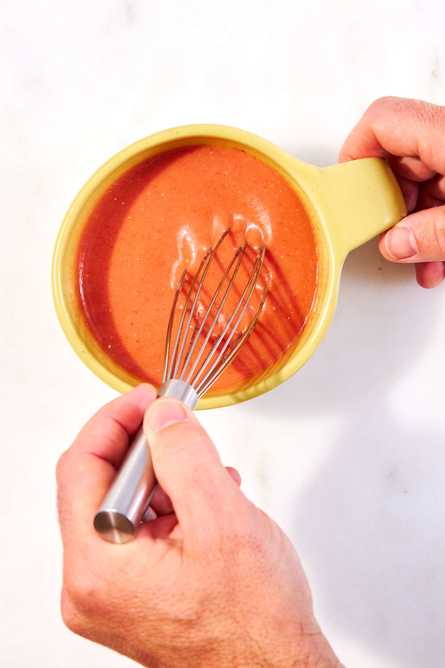 a photo of someone whisking the ingredients of the Quick Creamy Tomato Cup-of-Soup in a mug