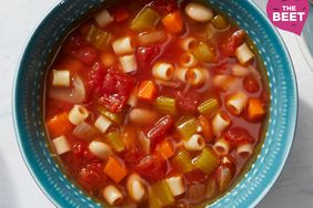 overhead shot of pasta e fagioli soup in a blue bowl with the beet logo