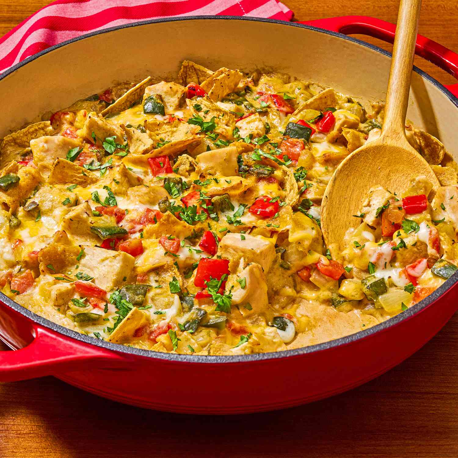Photo of Quick King Ranch Chicken Casserole in a skillet with a wooden spoon