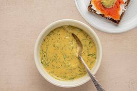 Overhead view of a bowl of Dill Mustard Sauce recipe next to a plate of smoked salmon