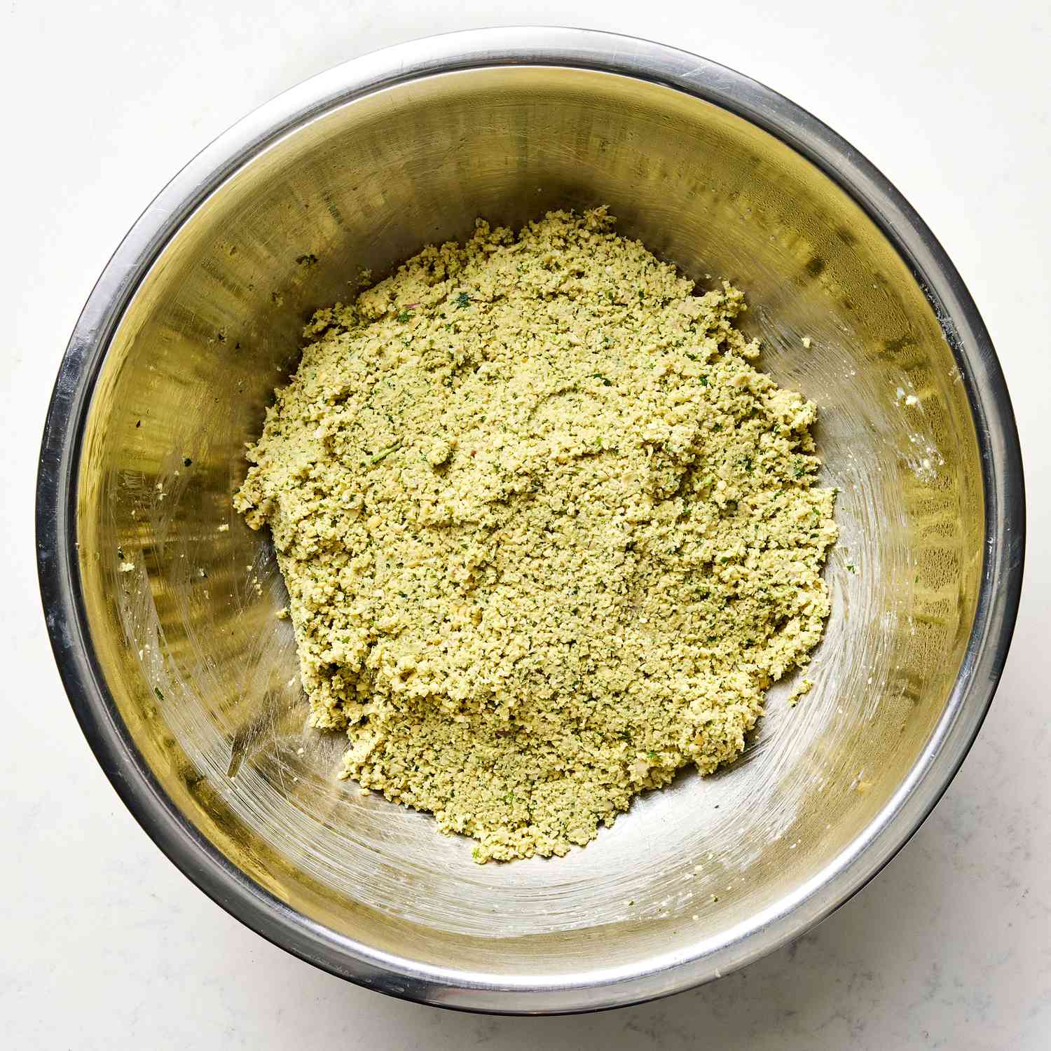 Falafel mixture pressed into a dough in a bowl