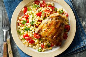 a grilled chicken thigh with a corn salad on the side