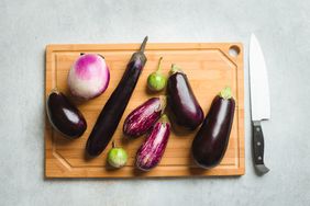 Different types of eggplant on a wooden cutting board