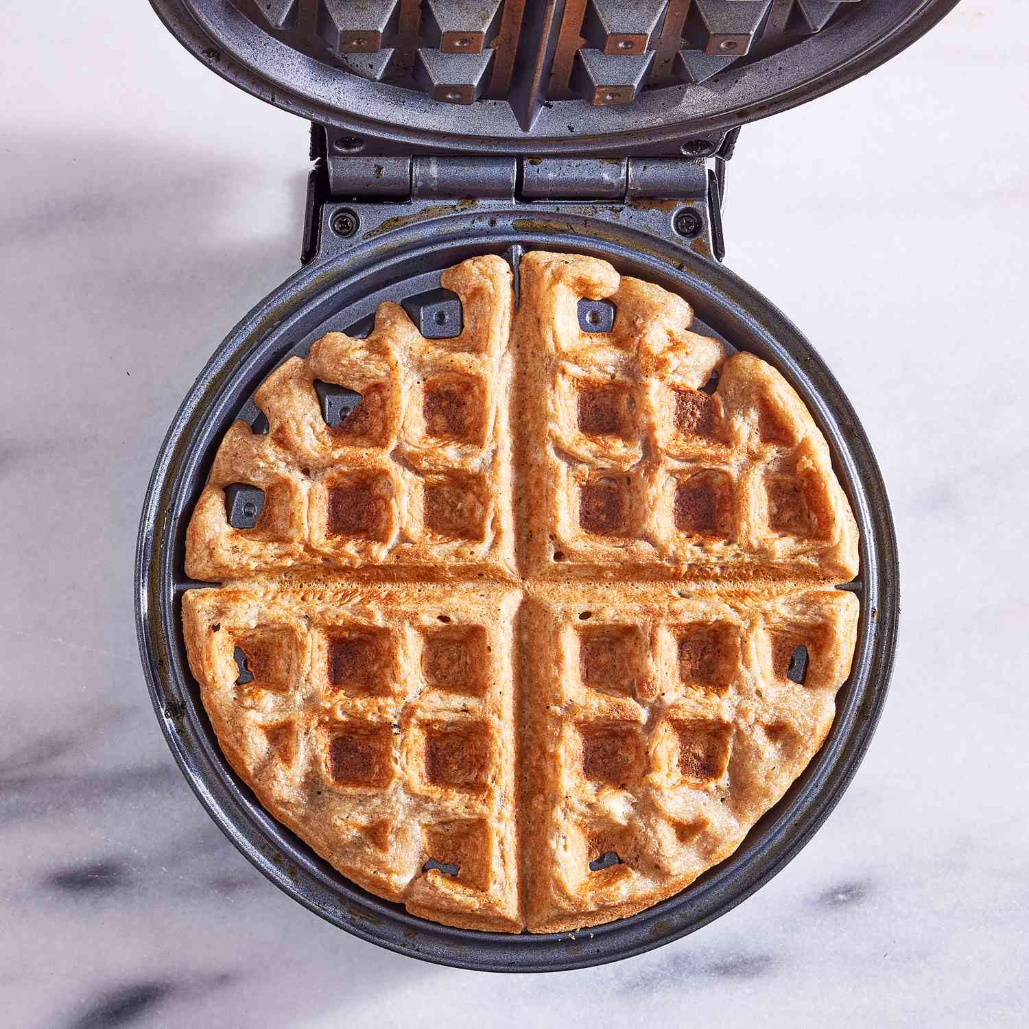 overhead view of cooked waffle in a waffle iron