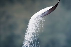 spoon pouring sugar into a pile