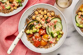Chickpea & quinoa grain bowl in a white shallow bowl, with a fork on the left side