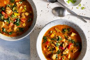 a recipe photo of the Chicken Tikka Masala Soup served in two bowls and topped with chives