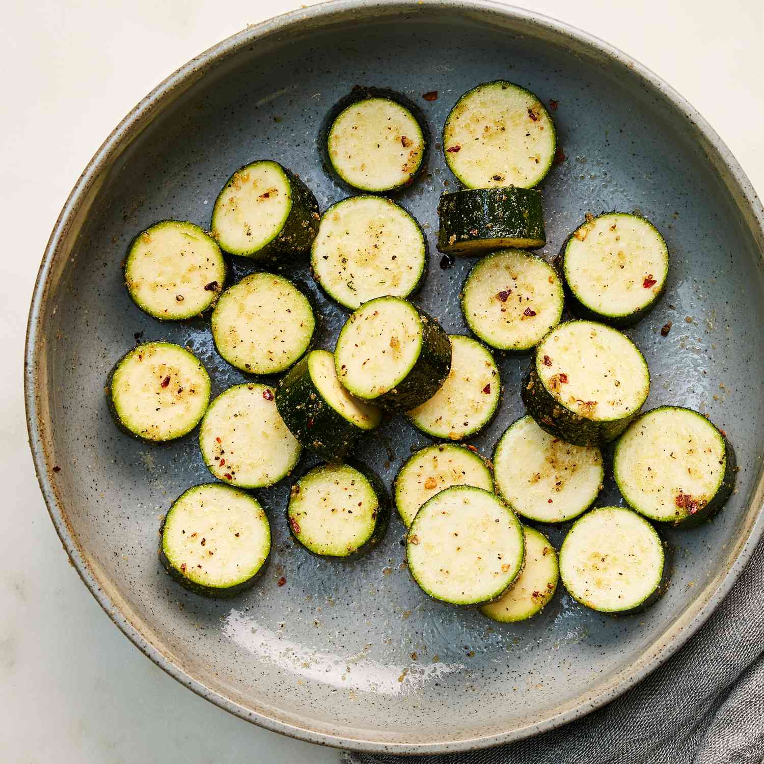 zucchini rounds in seasoning in a bowl