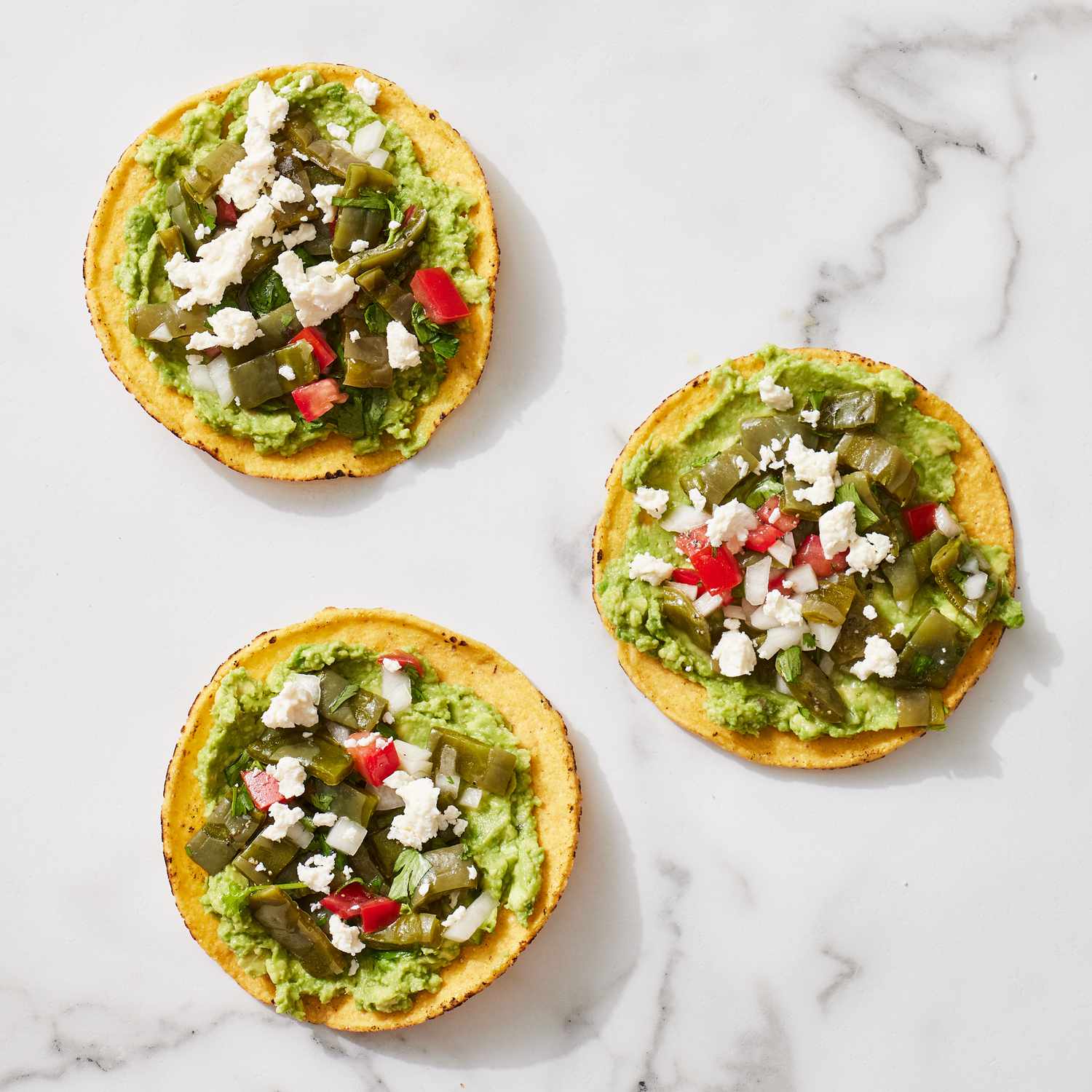 Three fully prepared tostadas for the tostadas con nopales y queso panela recipe