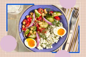 A bowl containing vegetables, chickpeas, and eggs arranged on a tabletop